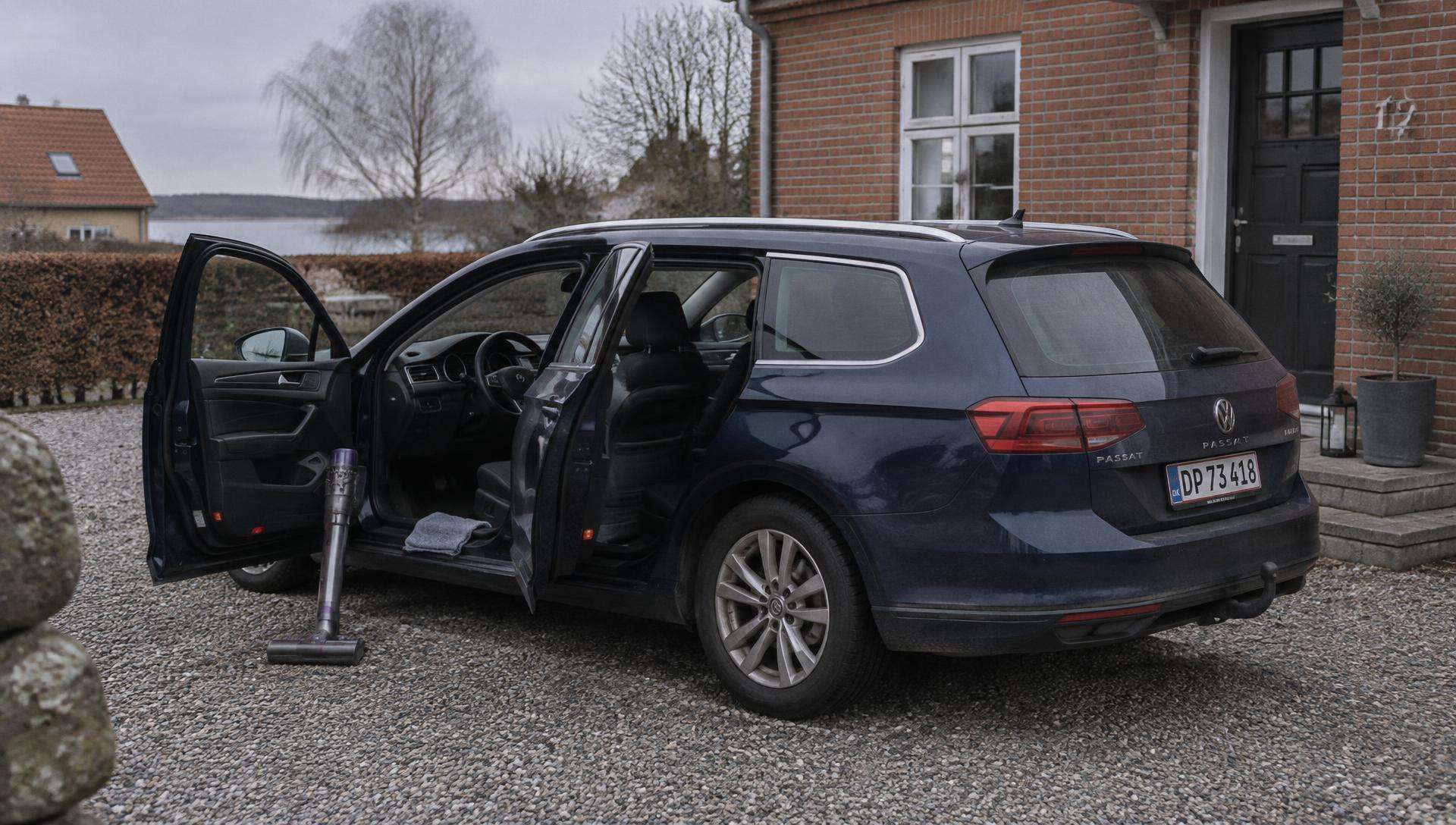 Bil holder i indkørslen med dørene åbne, klar til indvendig rengøring